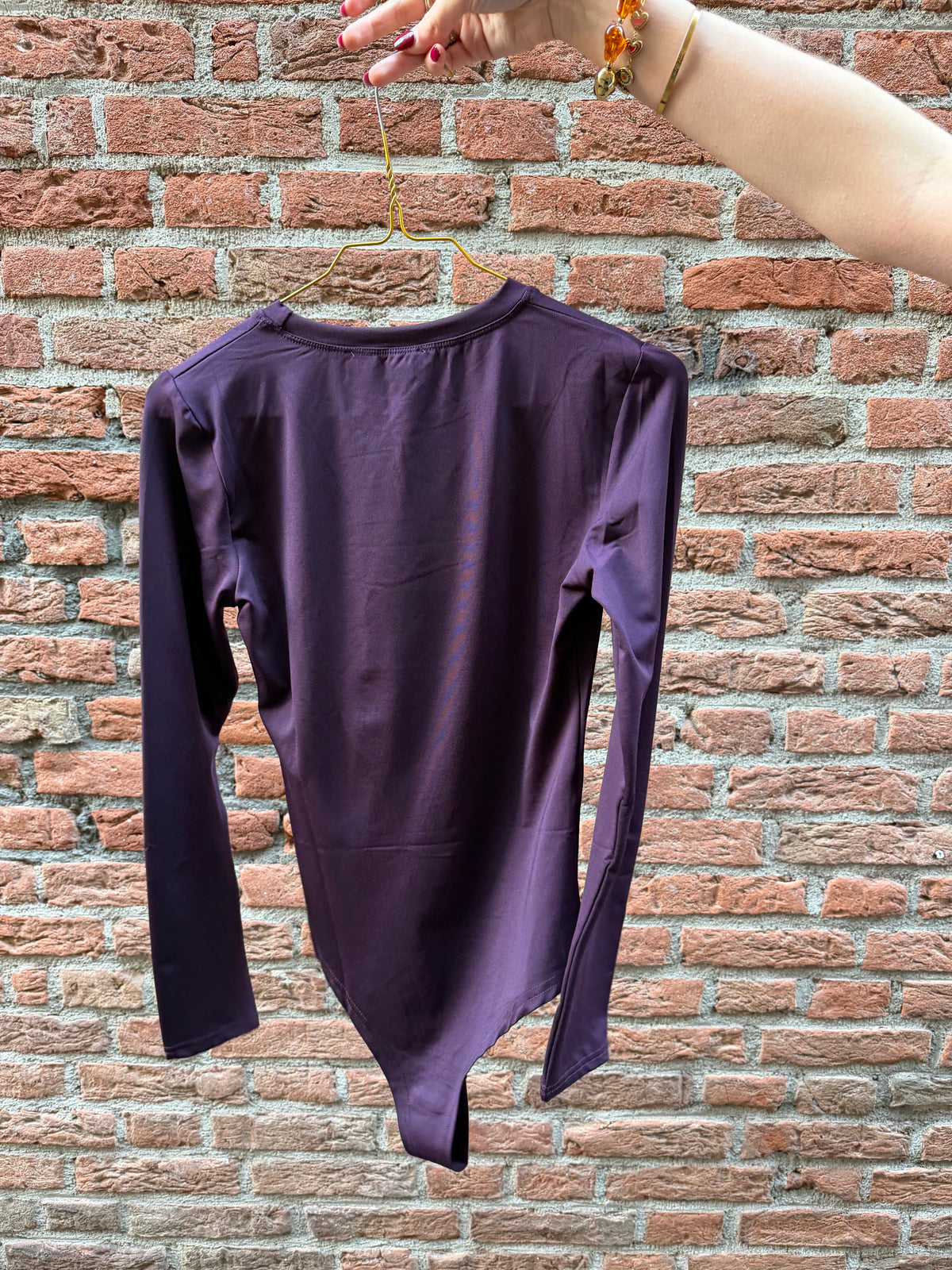 Body Faye Aubergine voor dames, aansluitende bodysuit in auberginekleur met lange mouwen en ronde hals.