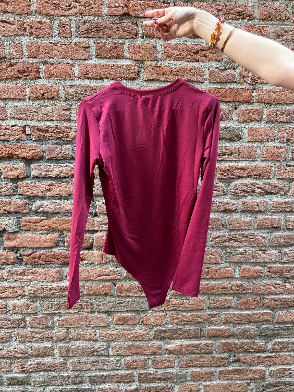 Body Faye Bordeaux voor dames, bordeauxrode aansluitende bodysuit met lange mouwen en ronde hals.